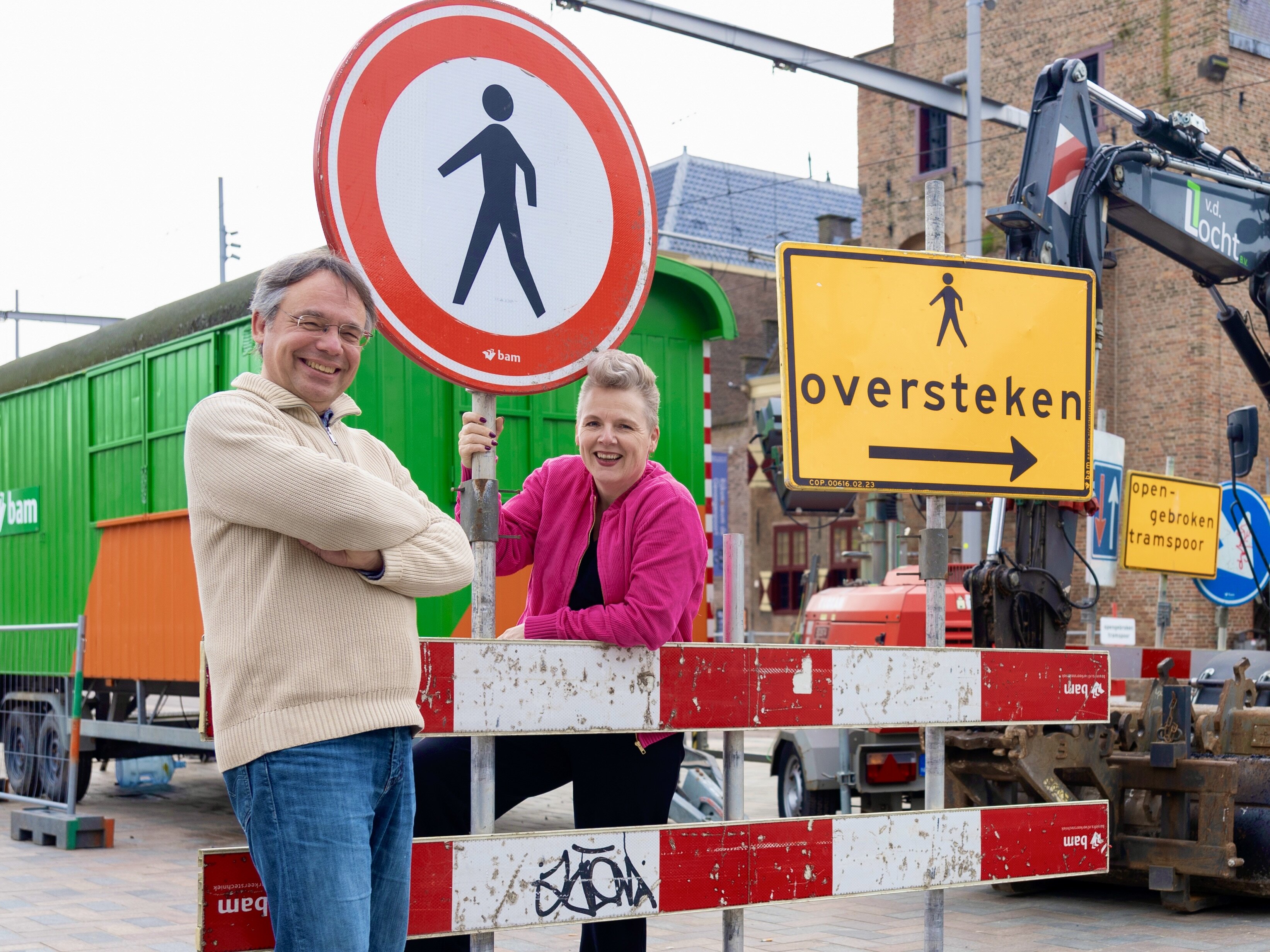 Collega's Bernhard en Ilona op straat in Den Haag, bij een plek met ontoegankelijke borden bij wegwerkzaamheden. 