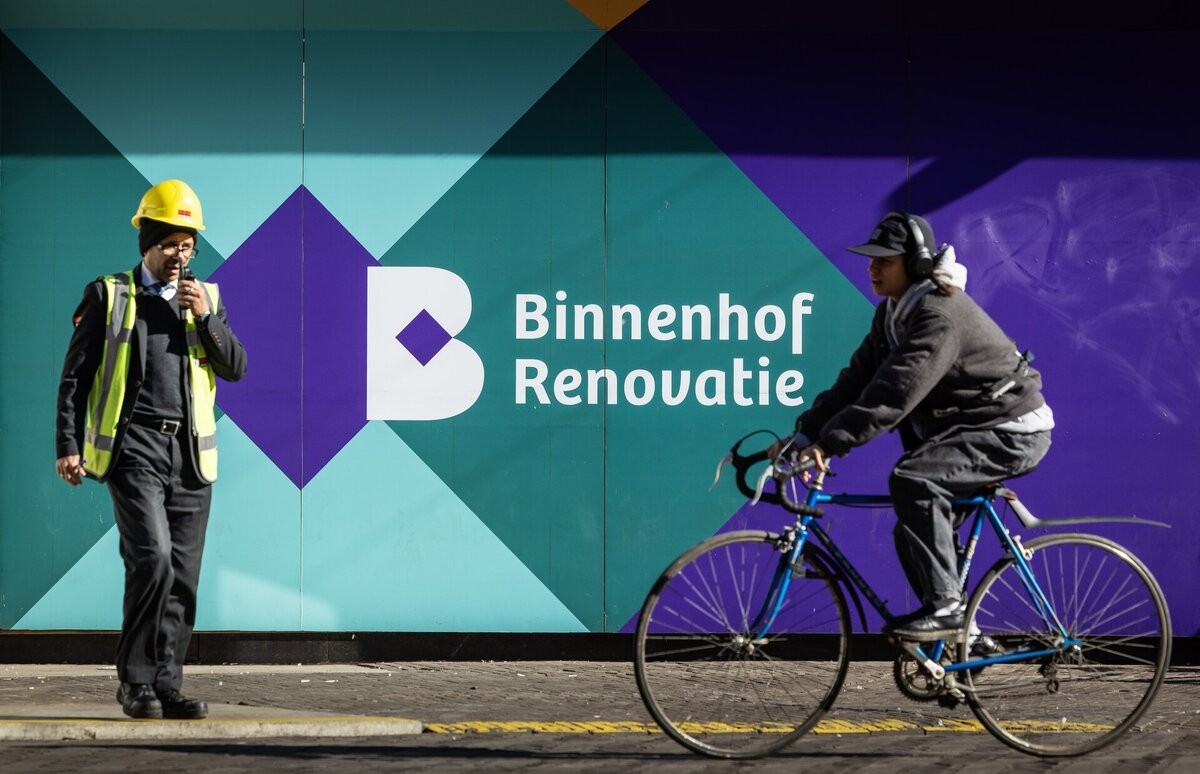 bouwschutting binnenhof renovatie met 2 mensen ervoor