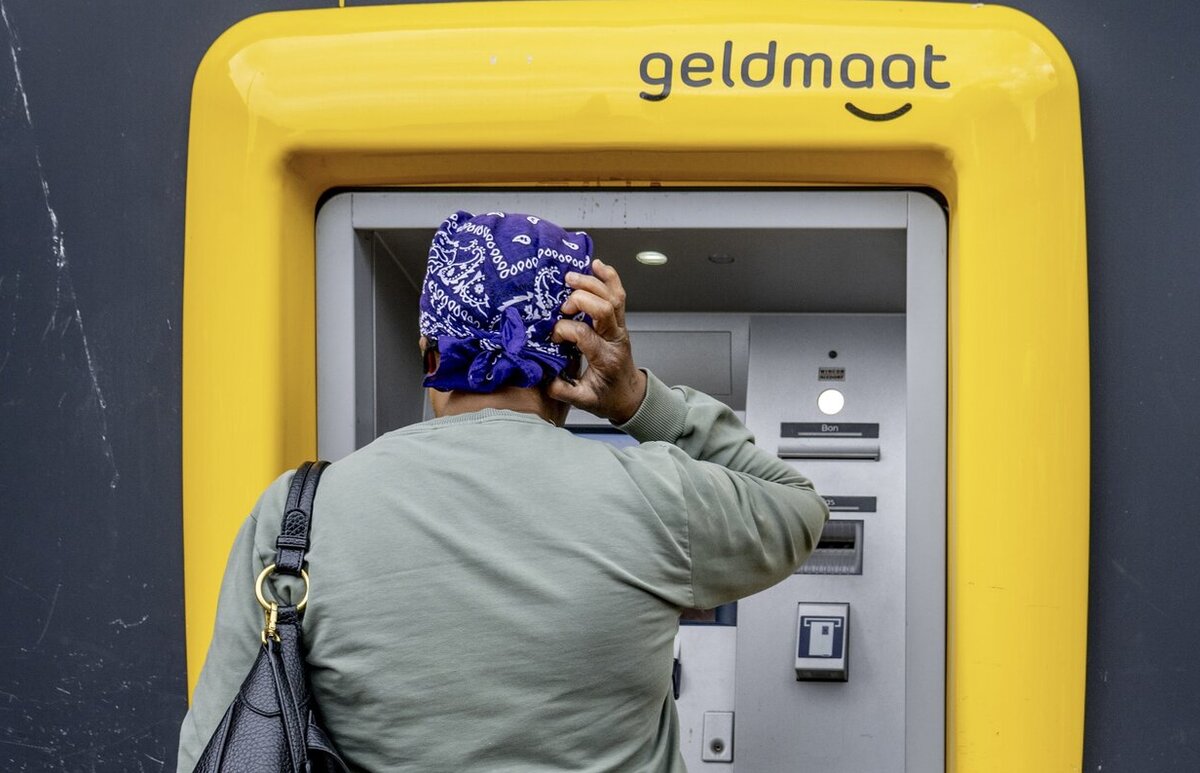 vrouw die contant geld pint bij een geldmaat